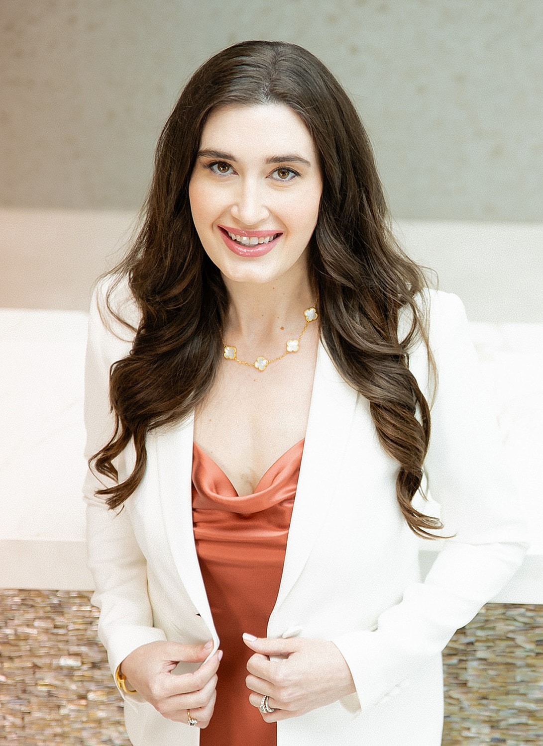 Professional woman in elegant attire, smiling.