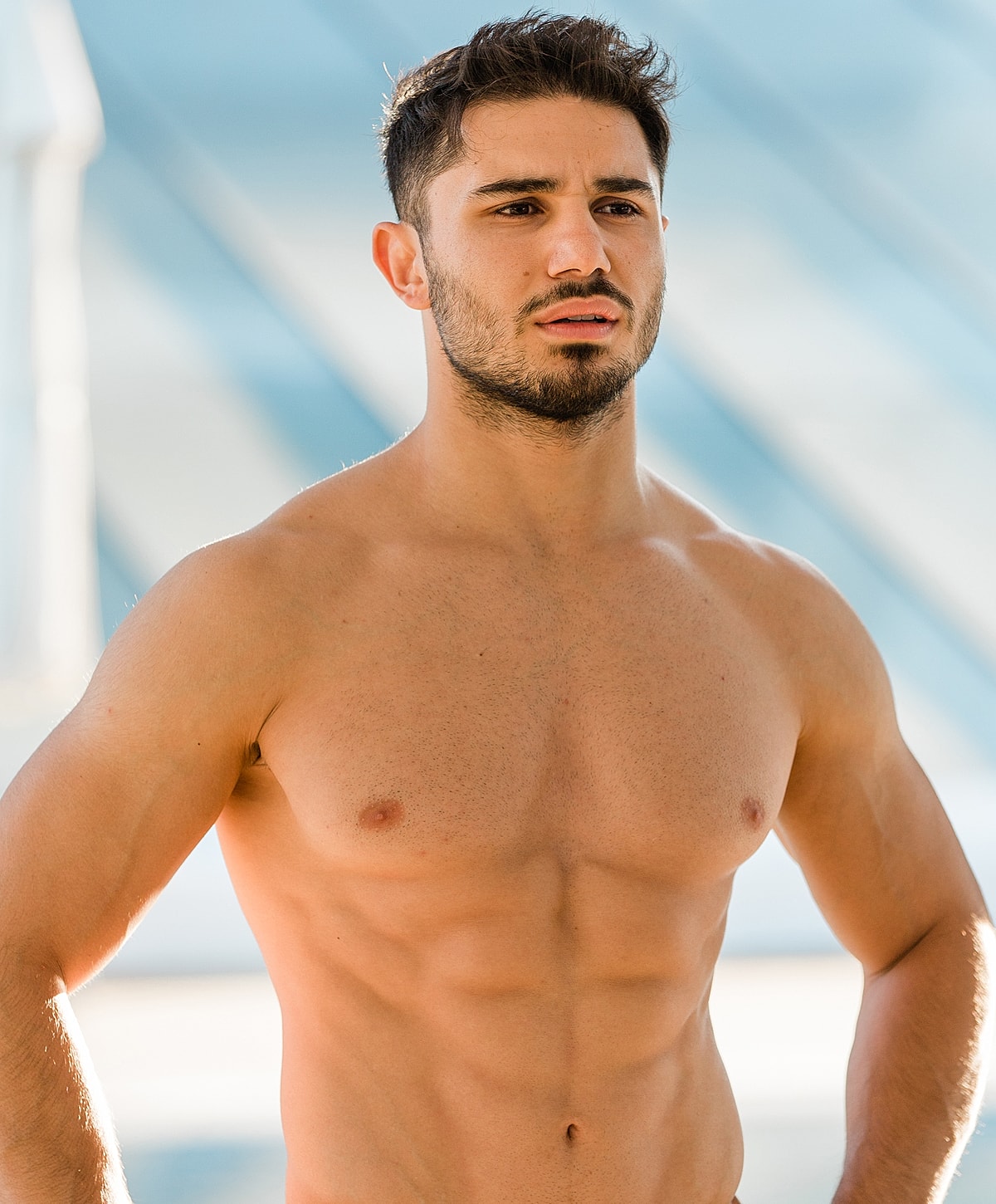 Athletic young man posing outdoors, wearing no shirt.